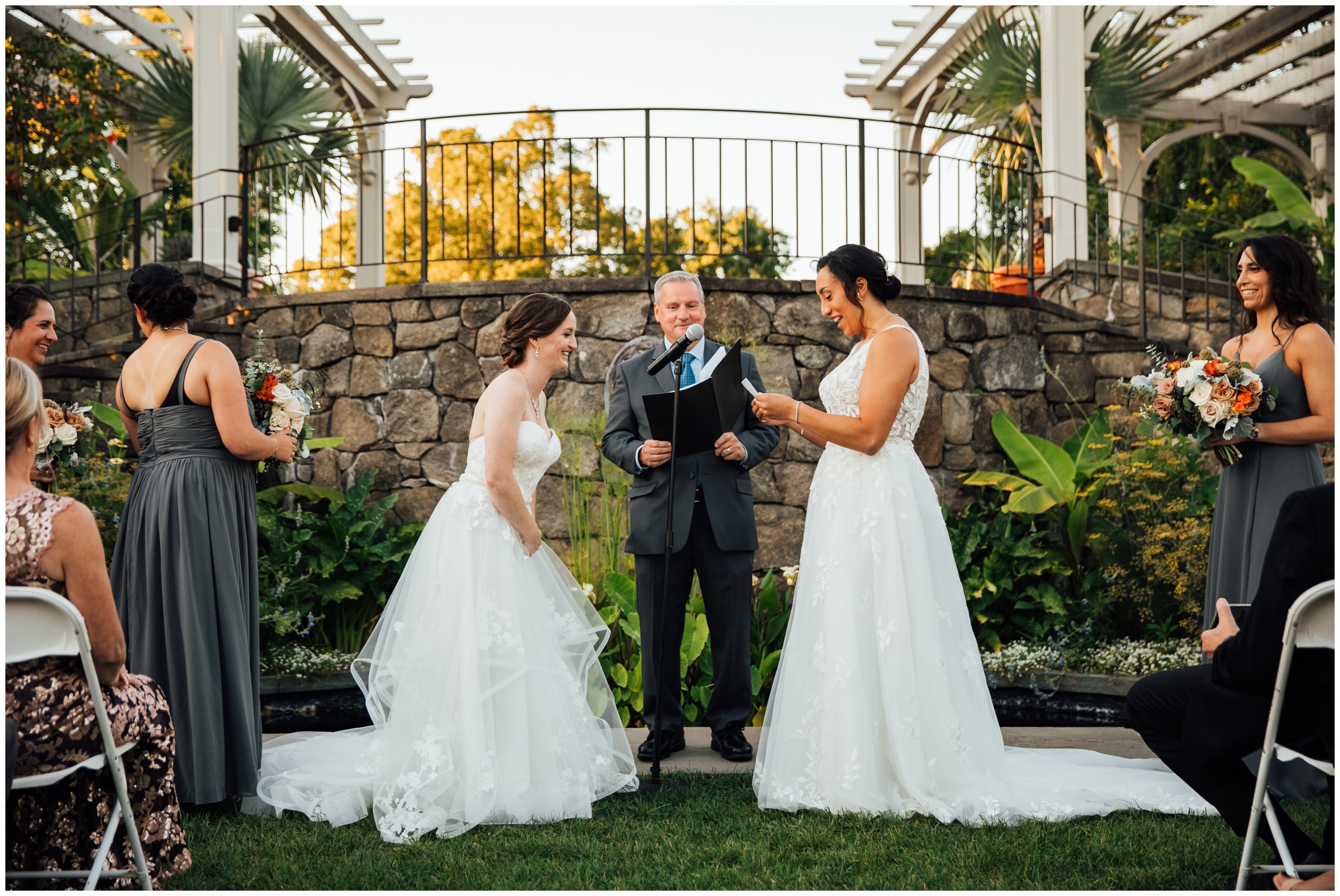 Two brides exchanging vows during outdoor ceremony at New England Botanic Garden at Tower Hill in Massachusetts